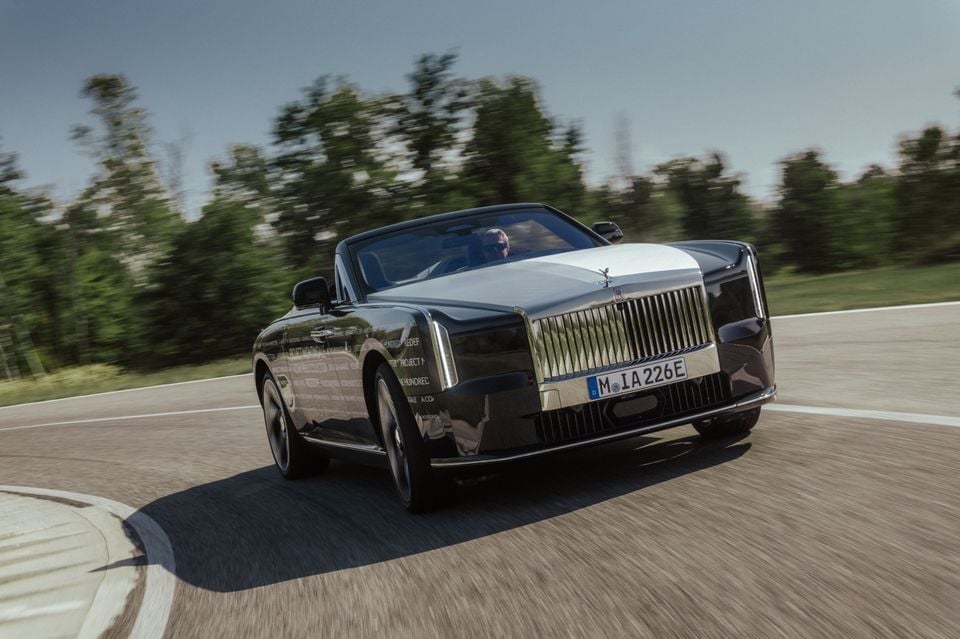 A Rolls-Royce Droptail convertible, camouflaged with test livery, drives on a track during on-road testing
