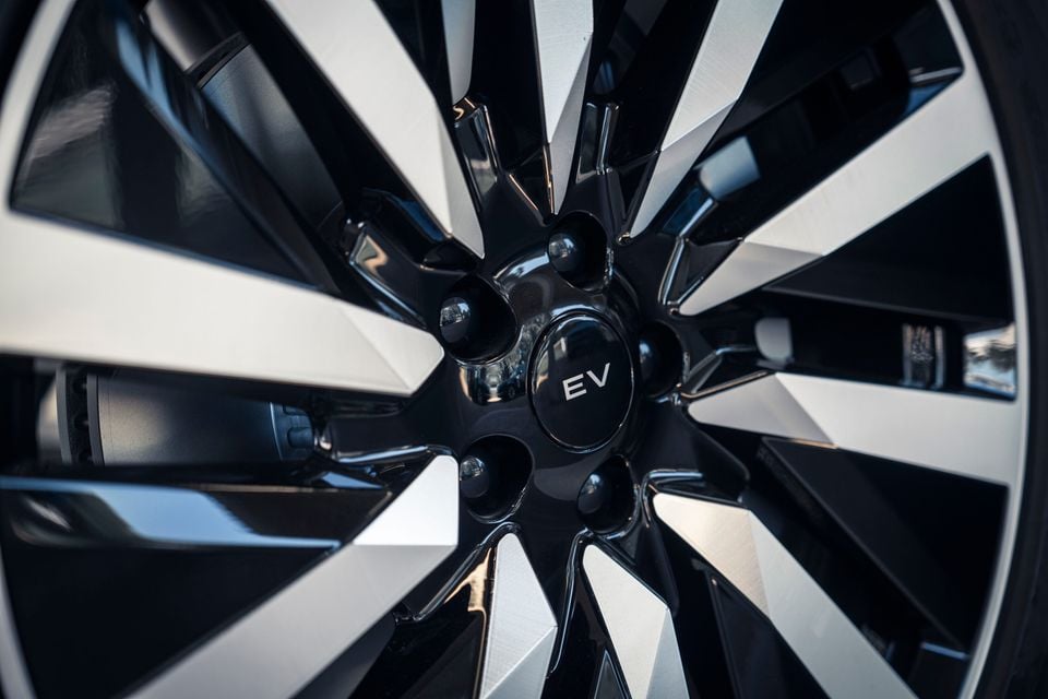 Close-up of a multi-spoke two-tone alloy wheel with an 'EV' centre cap on a Range Rover Sport Electric prototype