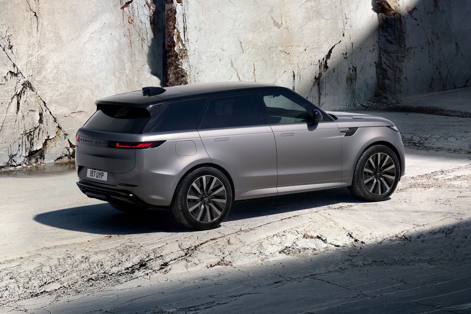 A grey Range Rover Sport SUV parked in a stone quarry, seen from the rear quarter angle.
