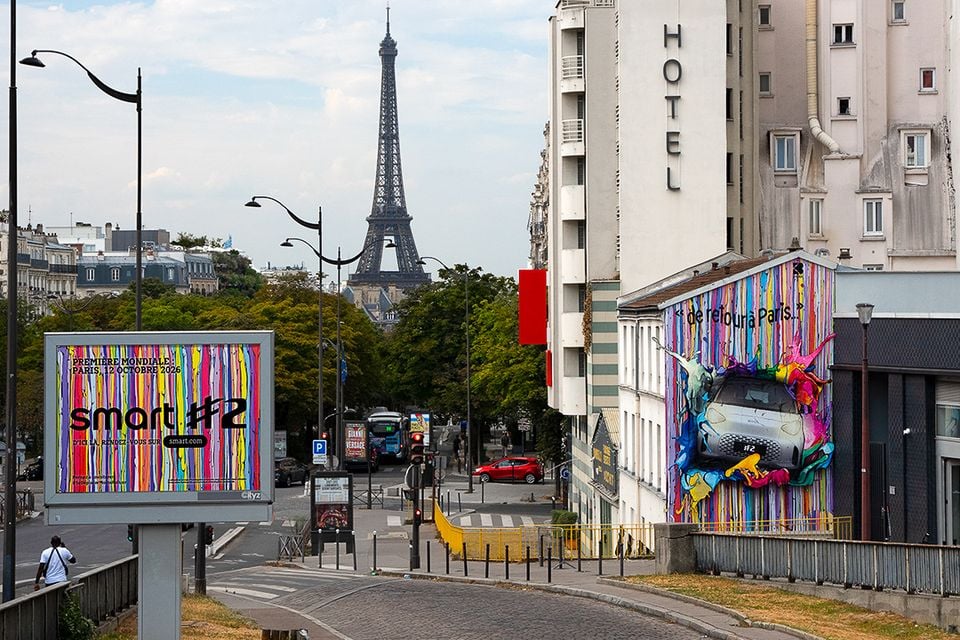 A Smart #2 advertising mural on a building wall and a billboard in Paris, with the Eiffel Tower visible in the background