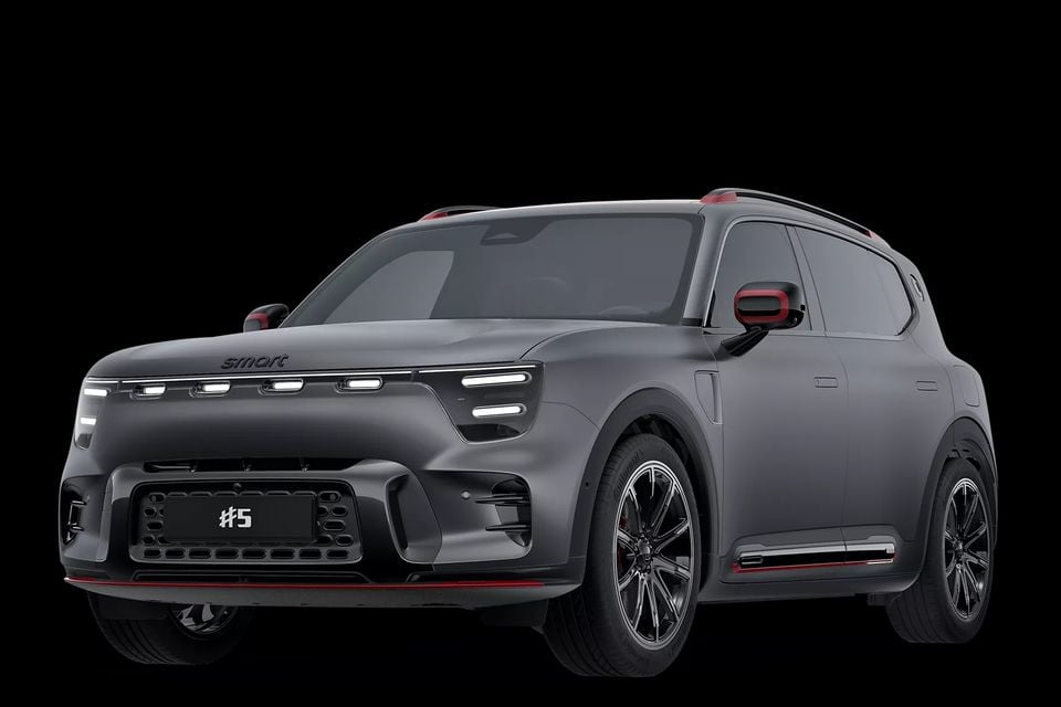 A dark grey Smart #5 Brabus SUV shown from a front three-quarter angle against a black background, featuring red accents and distinctive LED lighting