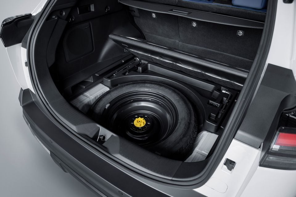 A spare wheel stored beneath the boot floor of a white Subaru Trailseeker SUV, viewed from the rear with the tailgate open.