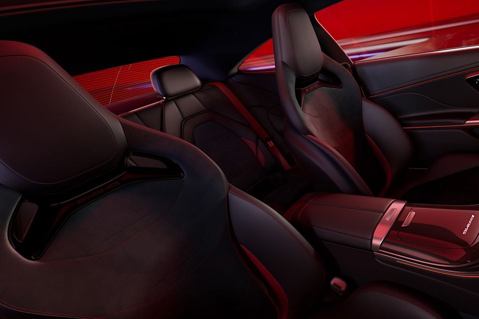 Interior of a Mercedes-AMG CLE 53 4MATIC Edition R showing dark leather bucket seats with red contrast stitching and AMG branding, red ambient lighting, and a carbon-fibre-trimmed centre console