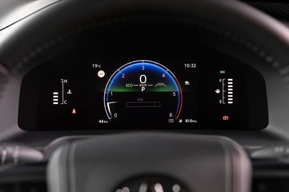 A digital instrument cluster display in a Toyota showing speed, ECO driving mode, fuel range of 810km, and various vehicle indicators