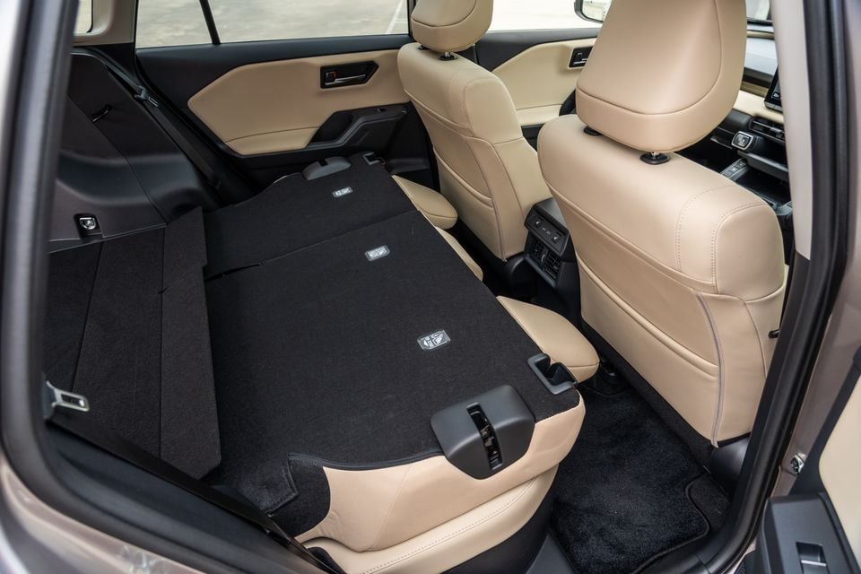 The rear seats of a Toyota RAV4 folded flat to expand cargo space, seen from the boot area.