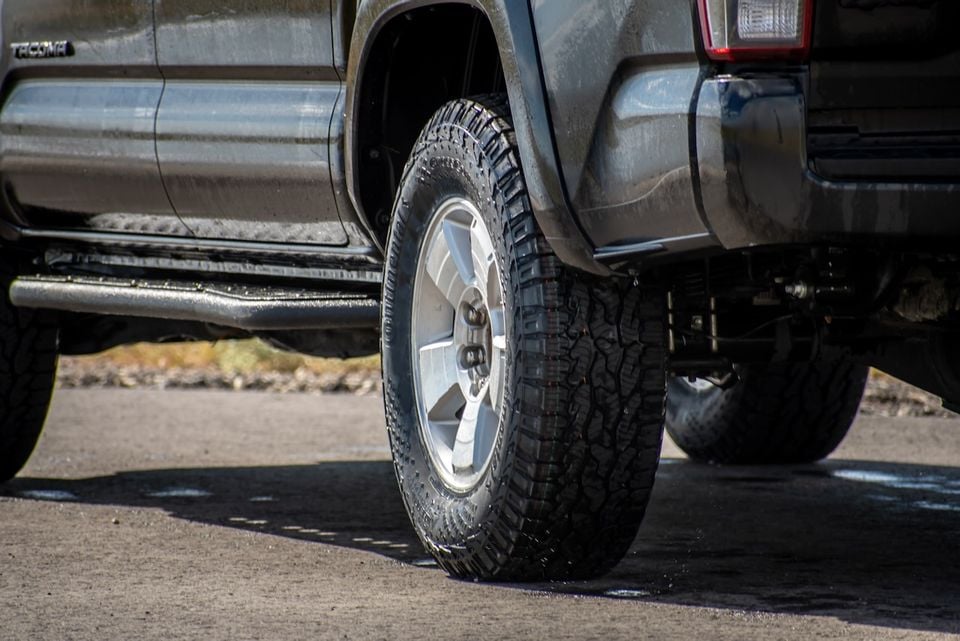 Close-up of the rear wheel and all-terrain tyre on a Toyota Tacoma ute, showing the alloy wheel and off-road tread pattern