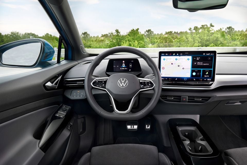 The interior of a Volkswagen ID.4 electric SUV, showing the steering wheel, digital instrument display and central touchscreen infotainment system.