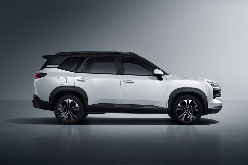 A white Wuling EKSion SUV with a black roof, seen from the side in a studio setting.