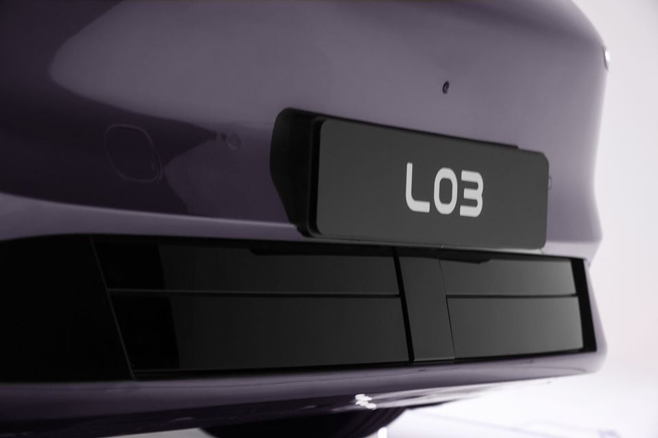 Close-up of the rear badge showing "L03" on a purple XPeng L03 SUV, with the lower bumper vents visible below.