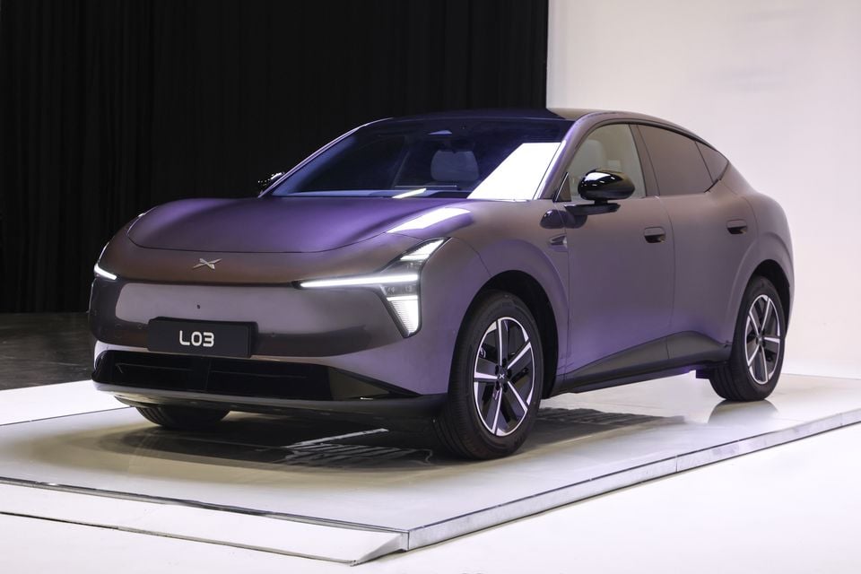 A purple Xpeng L03 sedan shown at an angle in a studio, revealing its front and side design