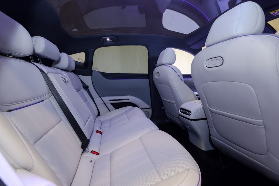The rear seats of an Xpeng G6, or similar SUV, shown in light grey leather upholstery with a panoramic sunroof overhead.