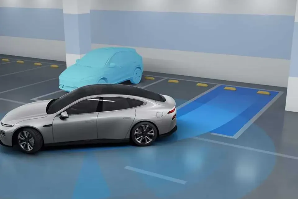 A digital illustration shows a silver Xpeng sedan using automated parking assist technology to reverse into a marked parking space in a car park, detecting a nearby car.