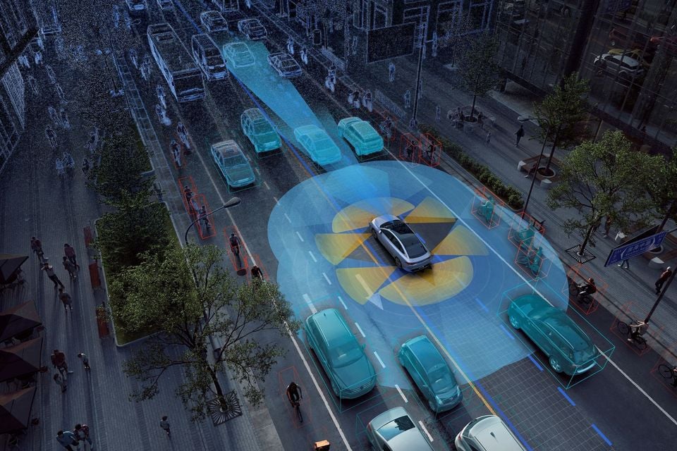 A digital illustration shows a car using driver-assistance sensors to detect surrounding vehicles, cyclists and pedestrians in a busy city street, viewed from above.