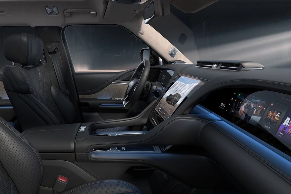 Dark leather cabin of the Yangwang U8 SUV with front seats, steering wheel, central touchscreen and passenger-side display, seen from the passenger side