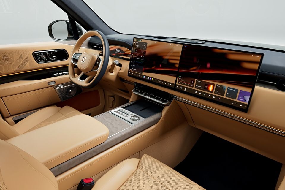 Interior of a Zeekr 9X showing tan leather seats, steering wheel, centre console, and a wide panoramic infotainment touchscreen display spanning the dashboard