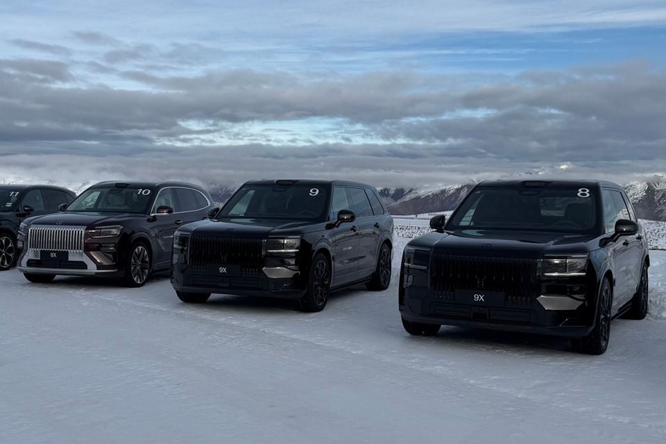 Multiple black Zeekr SUVs, including the 8X and 9X models, parked side by side on a snow-covered surface with a mountainous winter landscape in the background