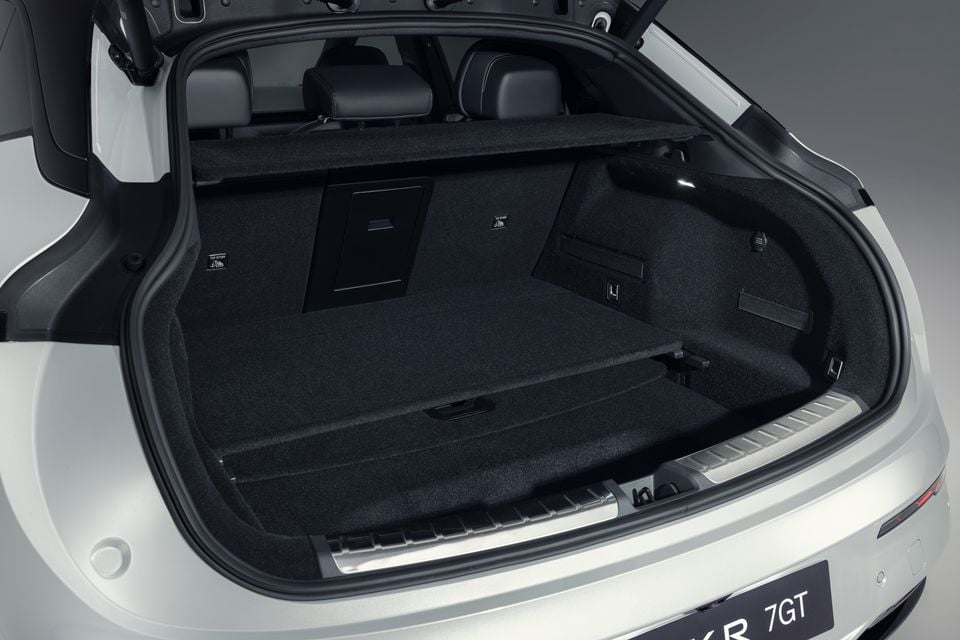 Open boot of a white Zeekr 7GT showing the carpeted cargo area with the tailgate raised
